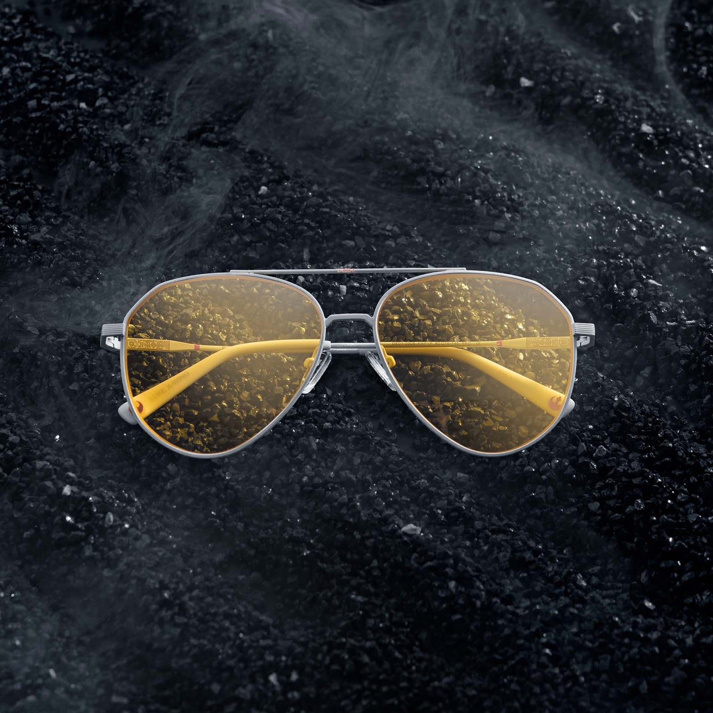 Flatlay of Star Wars x DIFF Luke Skywalker X-Wing sunglasses on rocky black soil with white smoke
