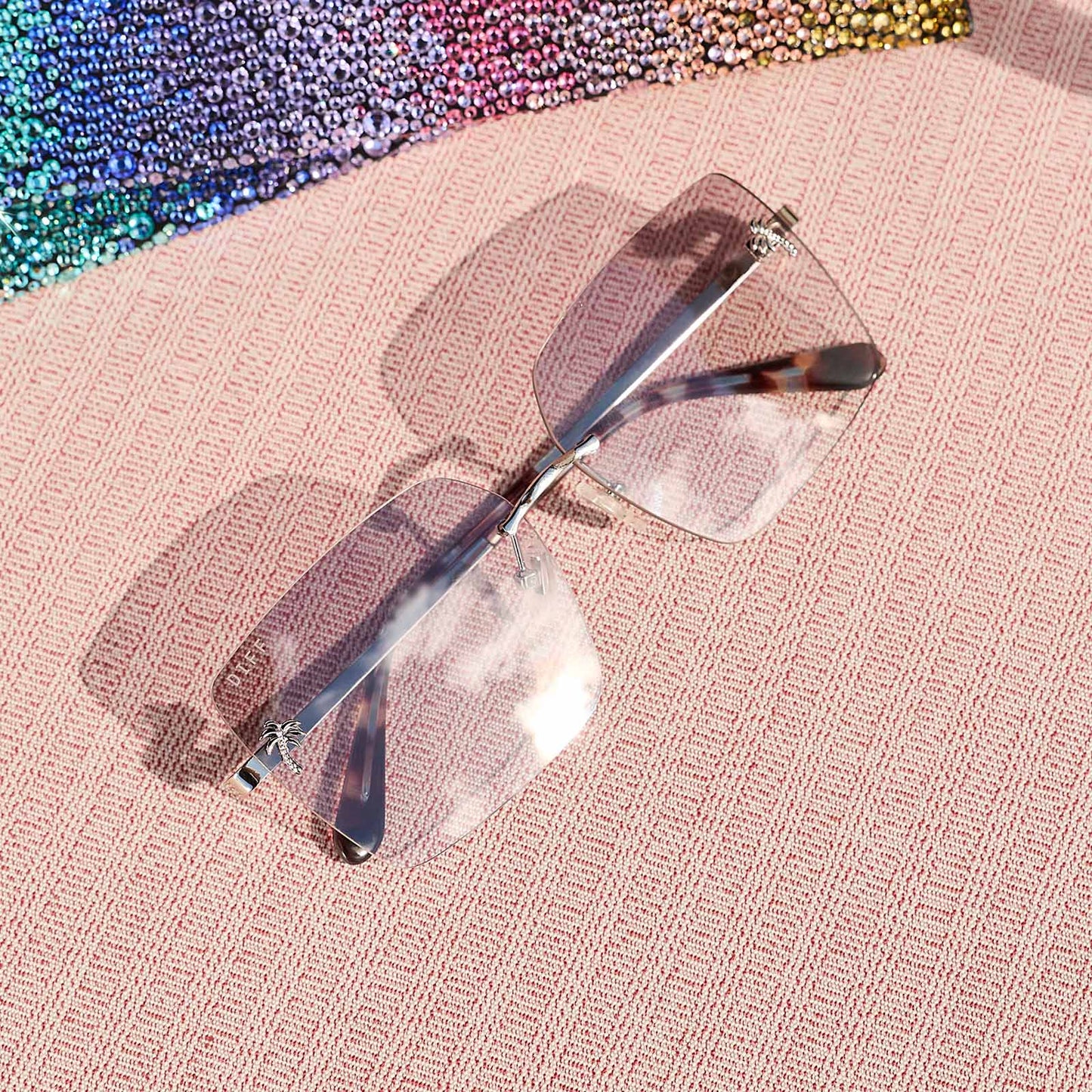 still life - jena sims x diff eyewear the rookie square sunglasses with a blue color pop and silver metal frame and sheer tint lenses 