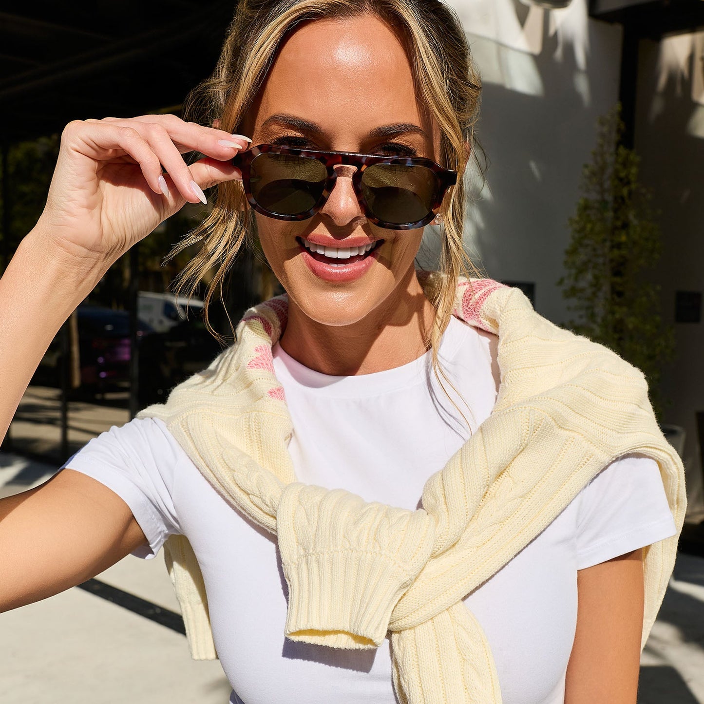lifestyle - jena sims taking off diff eyewear the sims navigator sunglasses with a blue color pop with gold metal frame and g15 polarized lenses