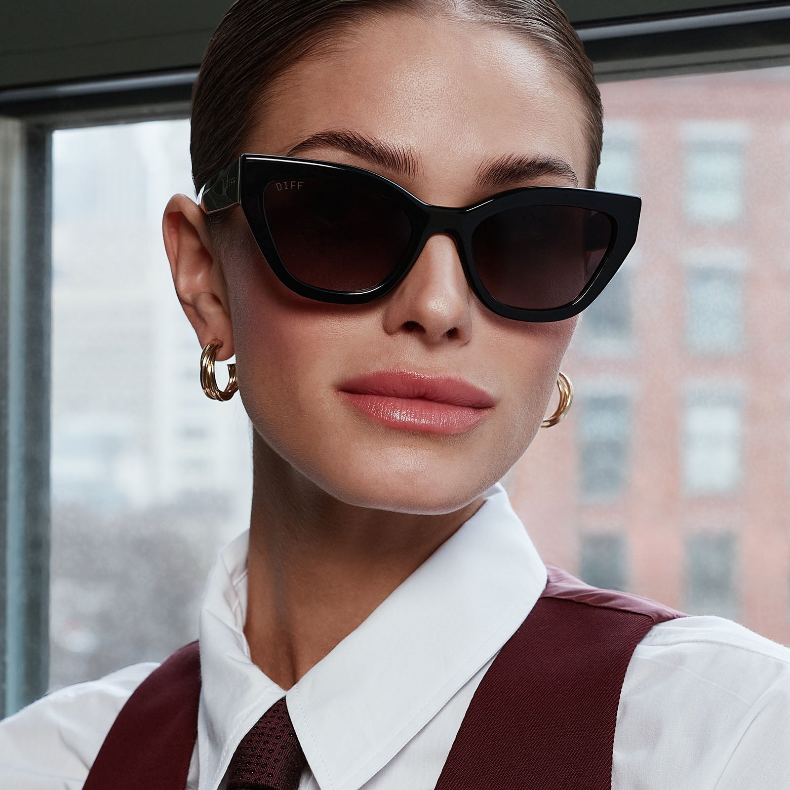 on model - female in the office about to go out wearing devil wears prada x diff eyewear emily black acetate sunglasses
