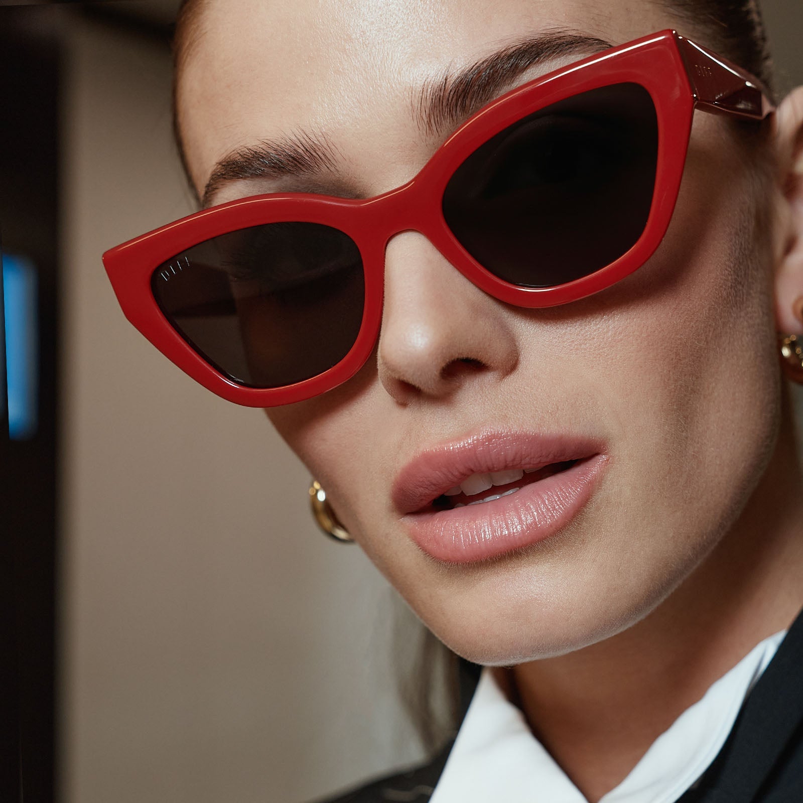 life style - business suited female wearing the devil wears prada x diff eyewear emily sunglasses in red close up view