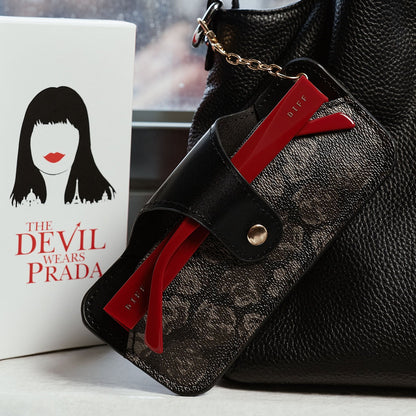 still life - the devil wears prada x diff eyewear emily sunglasses stored in carrying case attached to purse.
