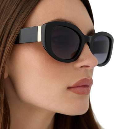 on model - female wearing the devil wears prada x diff eyewear featuring the miranda square oversized sunglasses with a black acetate frame and grey gradient polarized lenses angled view