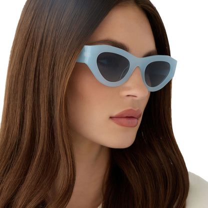 on model - female wearing for love and lemons x diff eyewear featuring the lucy cat eye sunglasses with a pastel blue frame and blue gradient polarized lenses detailed view
