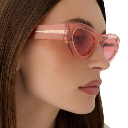on model - female wearing for love and lemons x diff eyewear featuring the lucy cat eye sunglasses with a pastel pink frame and rose lenses detailed view