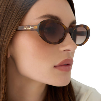 on model - female wearing for love and lemons x diff eyewear featuring the sabrina oval sunglasses with a honey tortoise frame and brown gradient lenses detailed view