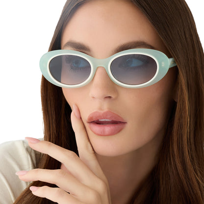 on model - female wearing for love and lemons x diff eyewear featuring the sabrina oval sunglasses with a pastel sage frame and blue gradient lenses front view