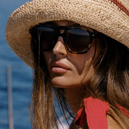 lifestyle - female on a boat wearing beach riot x diff eyewear the coast navigator sunglasses with a tortoise acetate frame and brown gradient lenses front view