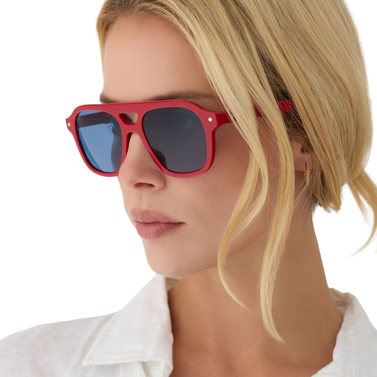 on model - female wearing beach riot x diff eyewear the coast navigator sunglasses with a red acetate frame and navy blue lenses angled view