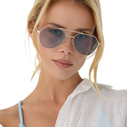 on model - female wearing beach riot x diff eyewear the reserve aviator sunglasses with a gold metal frame and blue tint lenses front view
