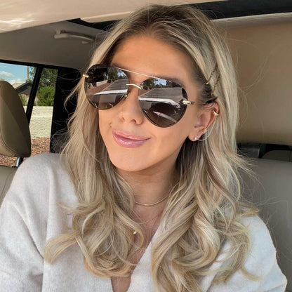 lifestyle - wink and a twirl wearing diff eyewear lenox aviator sunglasses with a gold, black metal frame and grey gradient polarized lenses