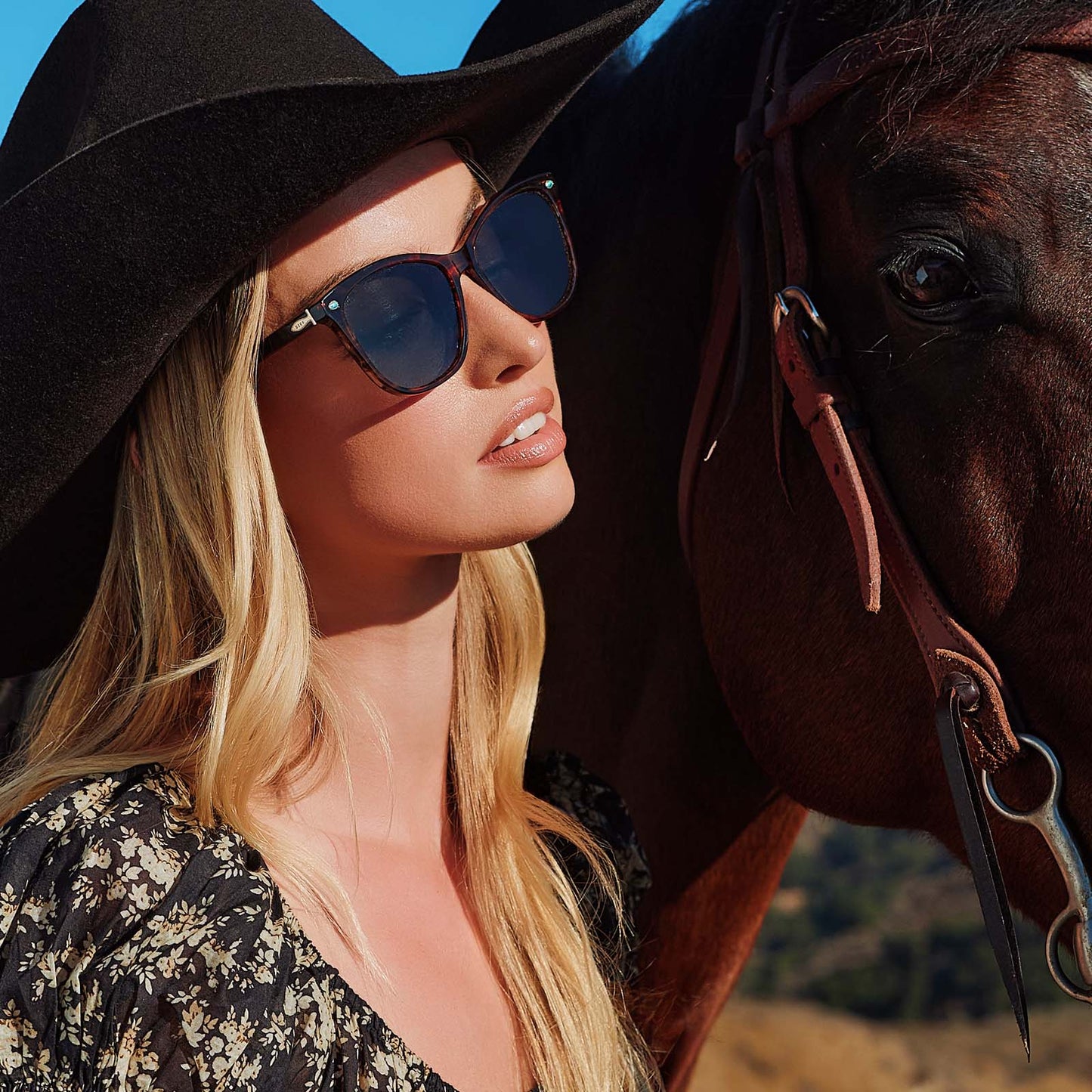 lifestyle - cowboy female with horse wearing yellowstone x diff eyewear featuring the beth iii cat eye sunglasses with a sequoia tortoise frame and g15 polarized lenses angled view