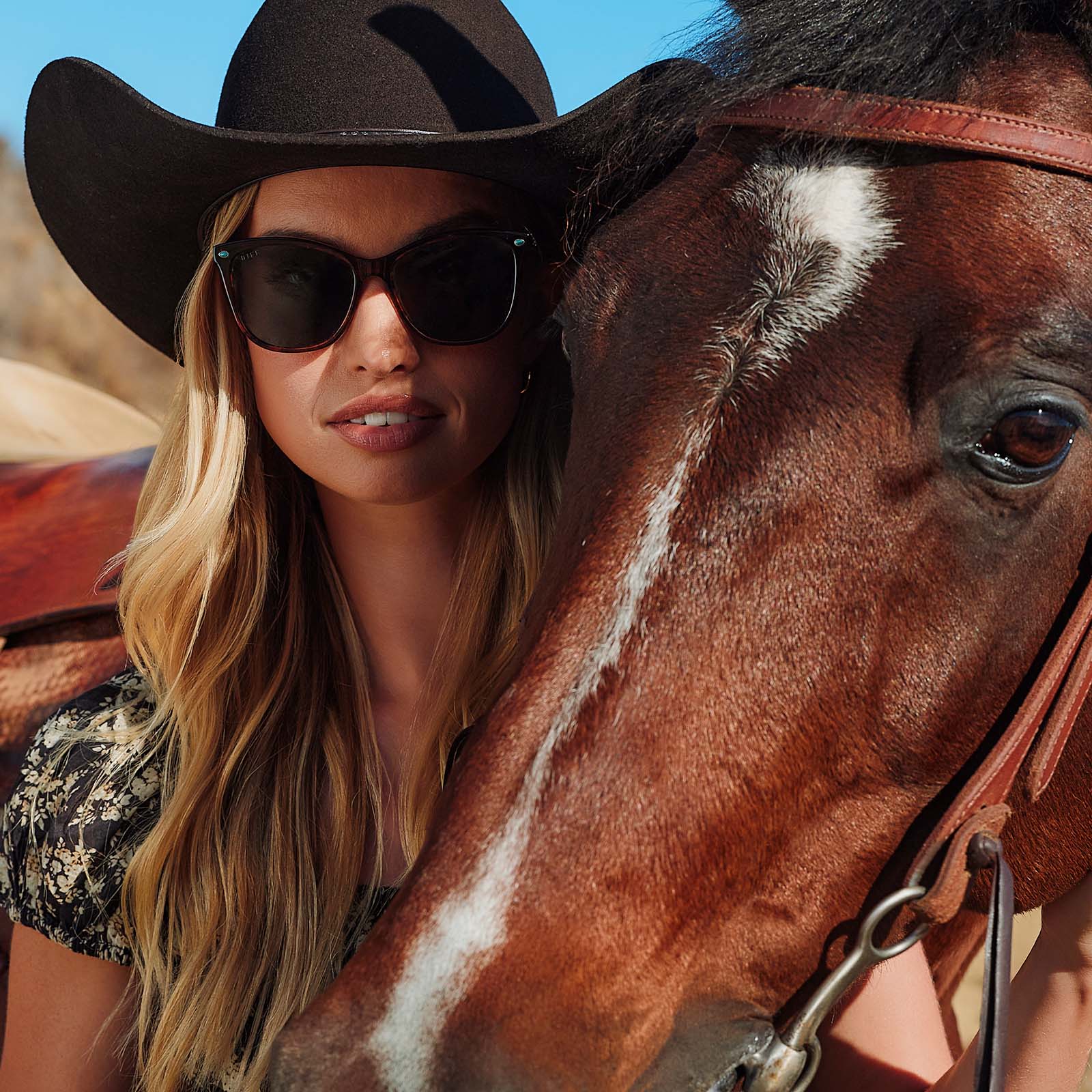 lifestyle - cowboy female with horse wearing yellowstone x diff eyewear featuring the beth iii cat eye sunglasses with a sequoia tortoise frame and g15 polarized lenses front view