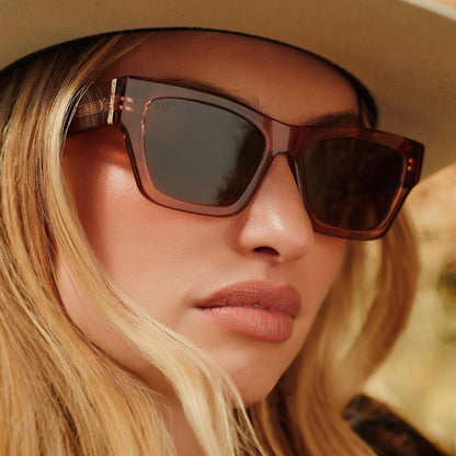 lifestyle - female wearing a cowboy hat also wearing yellowstone x diff eyewear featuring the beth ii cat eye sunglasses with a cafe ole frame and brown polarized lenses front view