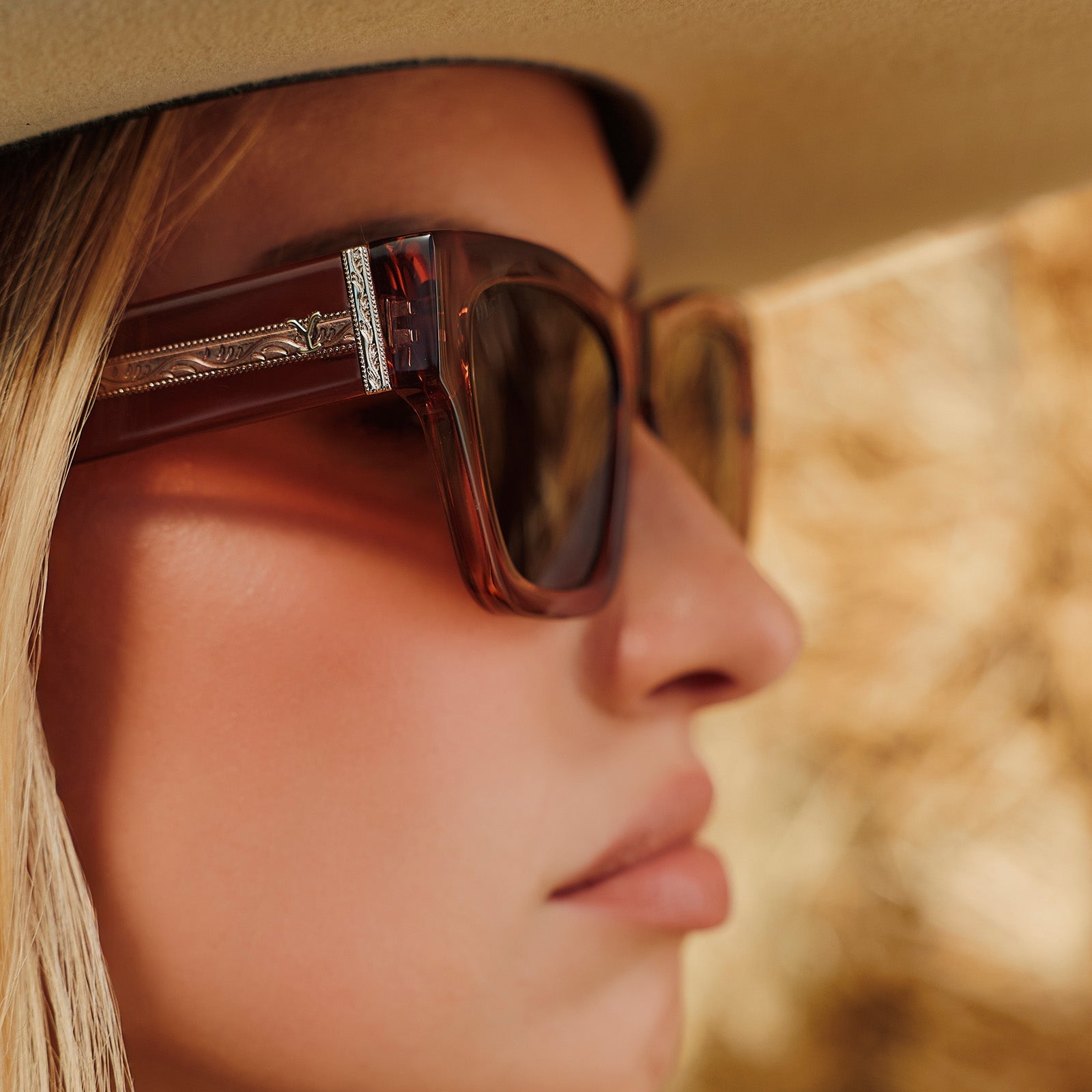 lifestyle - female wearing a cowboy hat also wearing yellowstone x diff eyewear featuring the beth ii cat eye sunglasses with a cafe ole frame and brown polarized lenses side view
