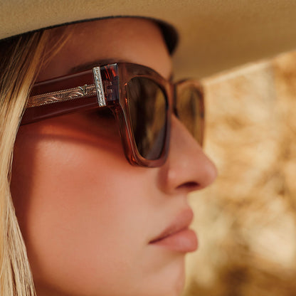 lifestyle - female wearing a cowboy hat also wearing yellowstone x diff eyewear featuring the beth ii cat eye sunglasses with a cafe ole frame and brown polarized lenses side view