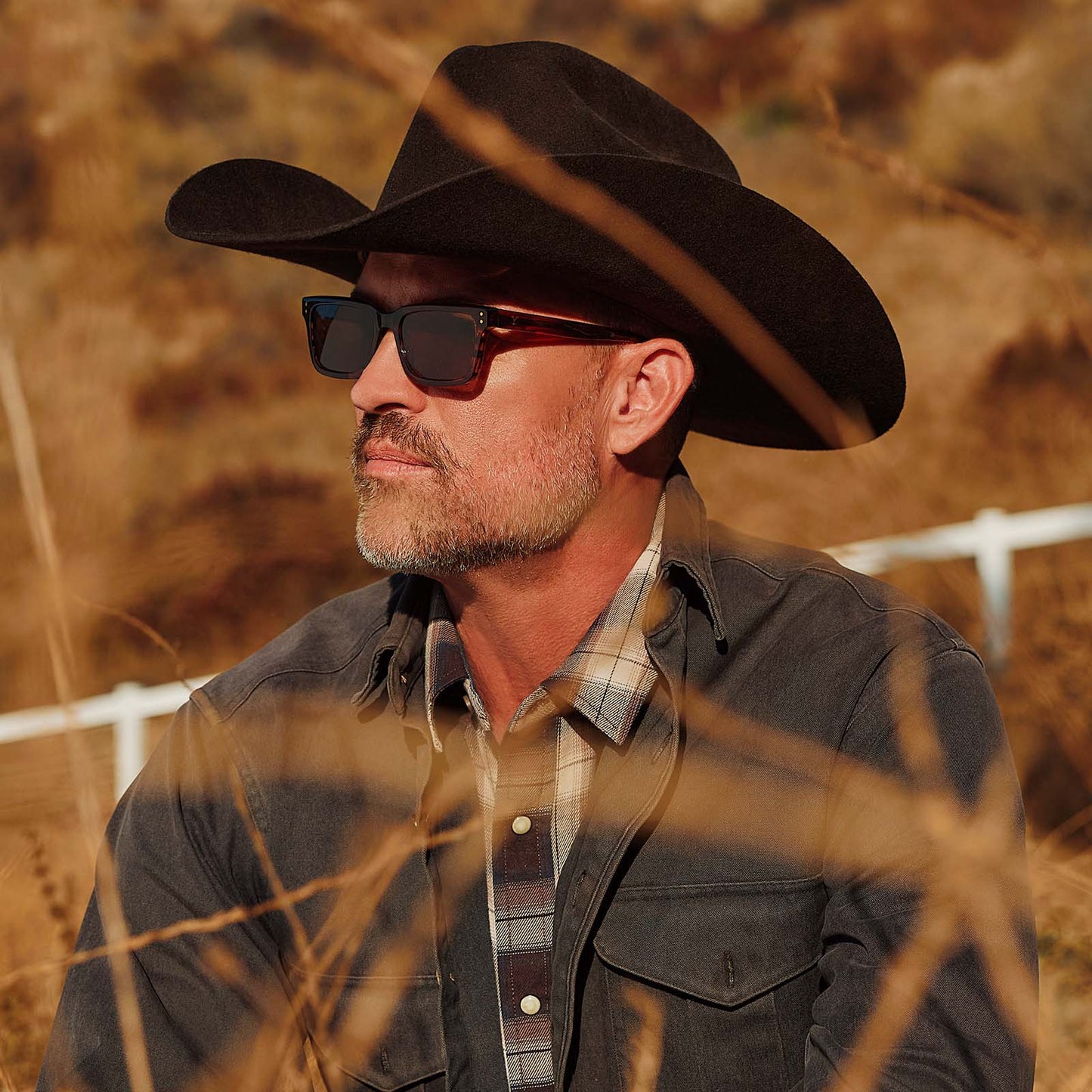 lifestyle - male with cowboy hat wearing yellowstone x diff eyewear featuring the john dutton rectangle sunglasses with a sequoia tortoise frame and brown polarized lenses side view