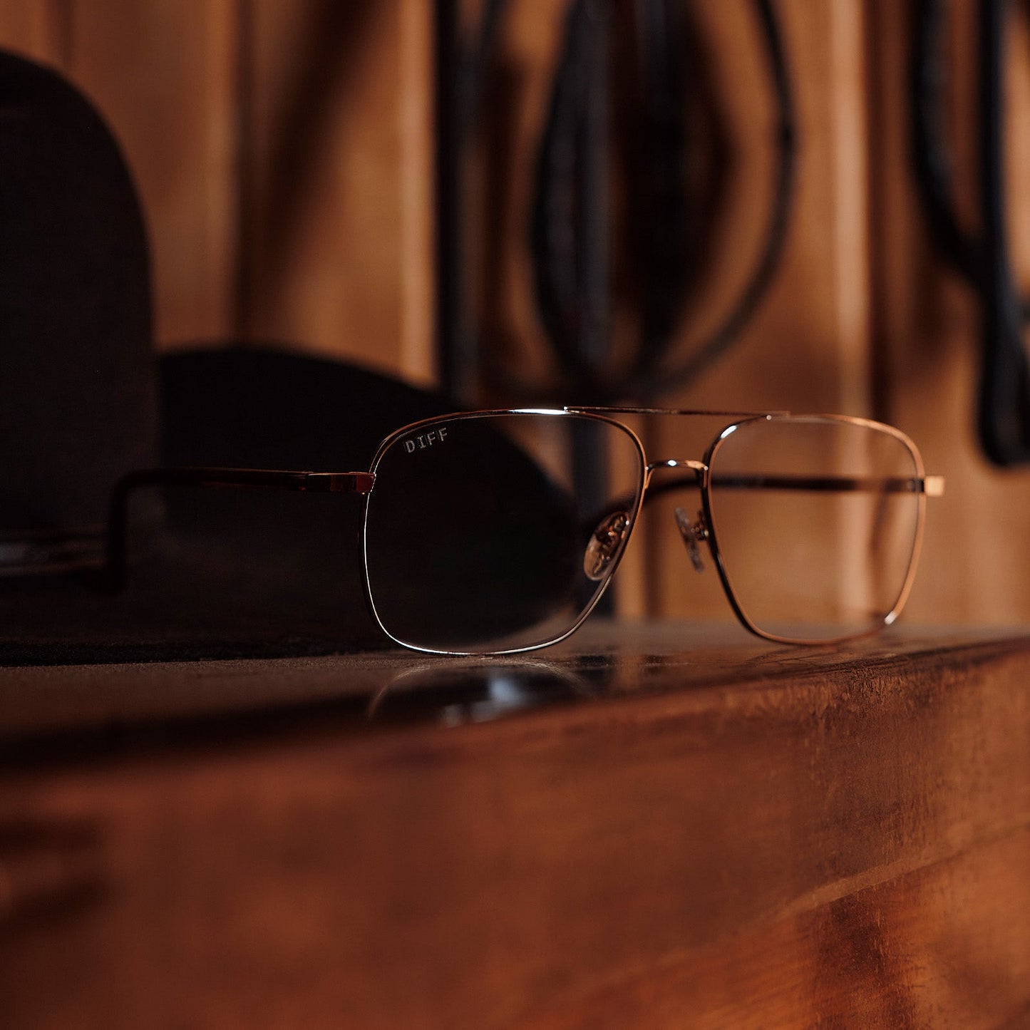 still life of yellowstone x diff eyewear featuring the rip wheeler navigator glasses with a gold frame front view