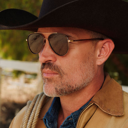 lifestyle - male in a cowboy hat wearing yellowstone x diff eyewear featuring the yellowstone aviator sunglasses with a sequoia tortoise frame and brown polarized lenses detailed view