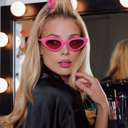 lifestyle - female in preping in studio wearing emily in paris x diff eyewear featuring the emily 2.0 cateye sunglasses with a parisian pink frame and maracon pink lenses front view