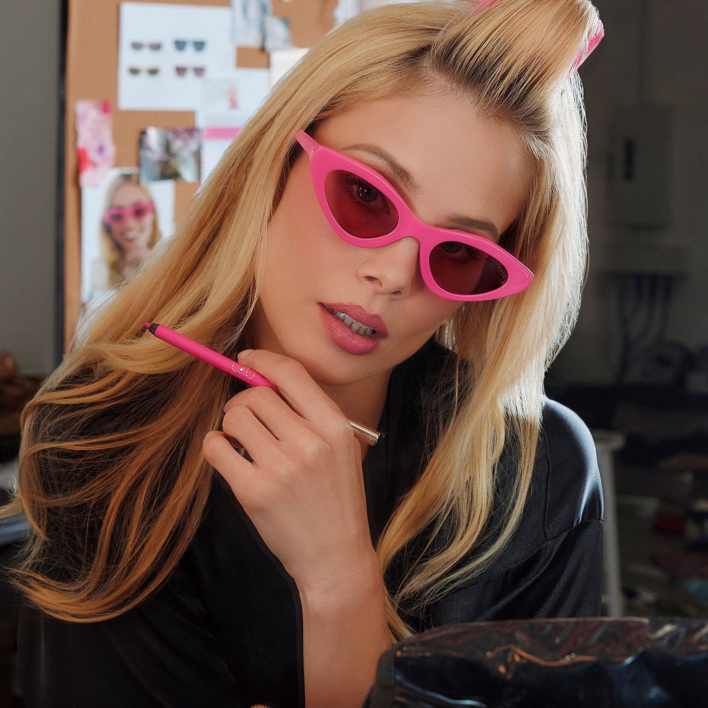 lifestyle - female in preping in studio doing her make up wearing emily in paris x diff eyewear featuring the emily 2.0 cateye sunglasses with a parisian pink frame and maracon pink lenses front view