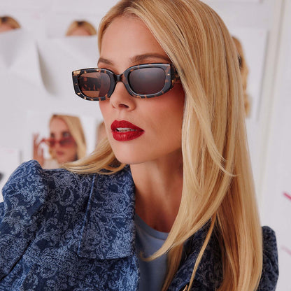 lifestyle - female in photo studio trying on emily in paris x diff eyewear featuring the julien 2.0 rectangle sunglasses with a classic tortoise frame and warm brown lenses angled view