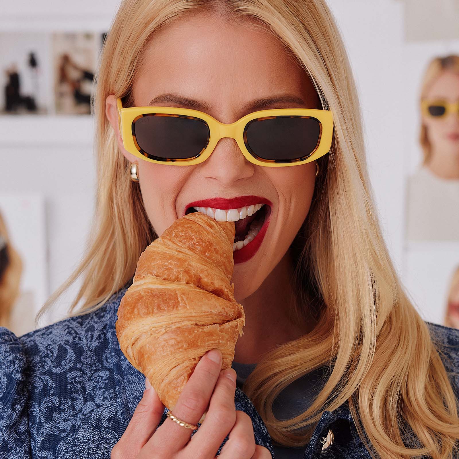 lifestyle - female in photo studio eating a croissant while trying on emily in paris x diff eyewear featuring the julien 2.0 rectangle sunglasses with a citron yellow with tortoise frame and chic grey lenses front view