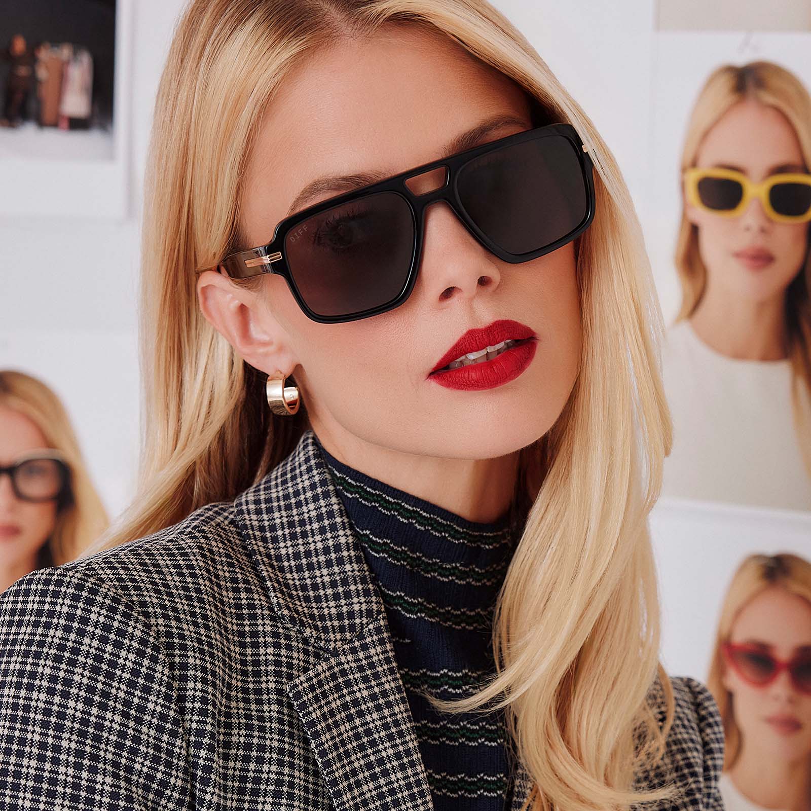 lifestyle - female in photo studio trying on emily in paris x diff eyewear featuring the julien navigator sunglasses with a jet noir black frame and smoke black lenses front view