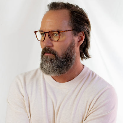 male wearing the griffin in amber tortoise and blue light readers