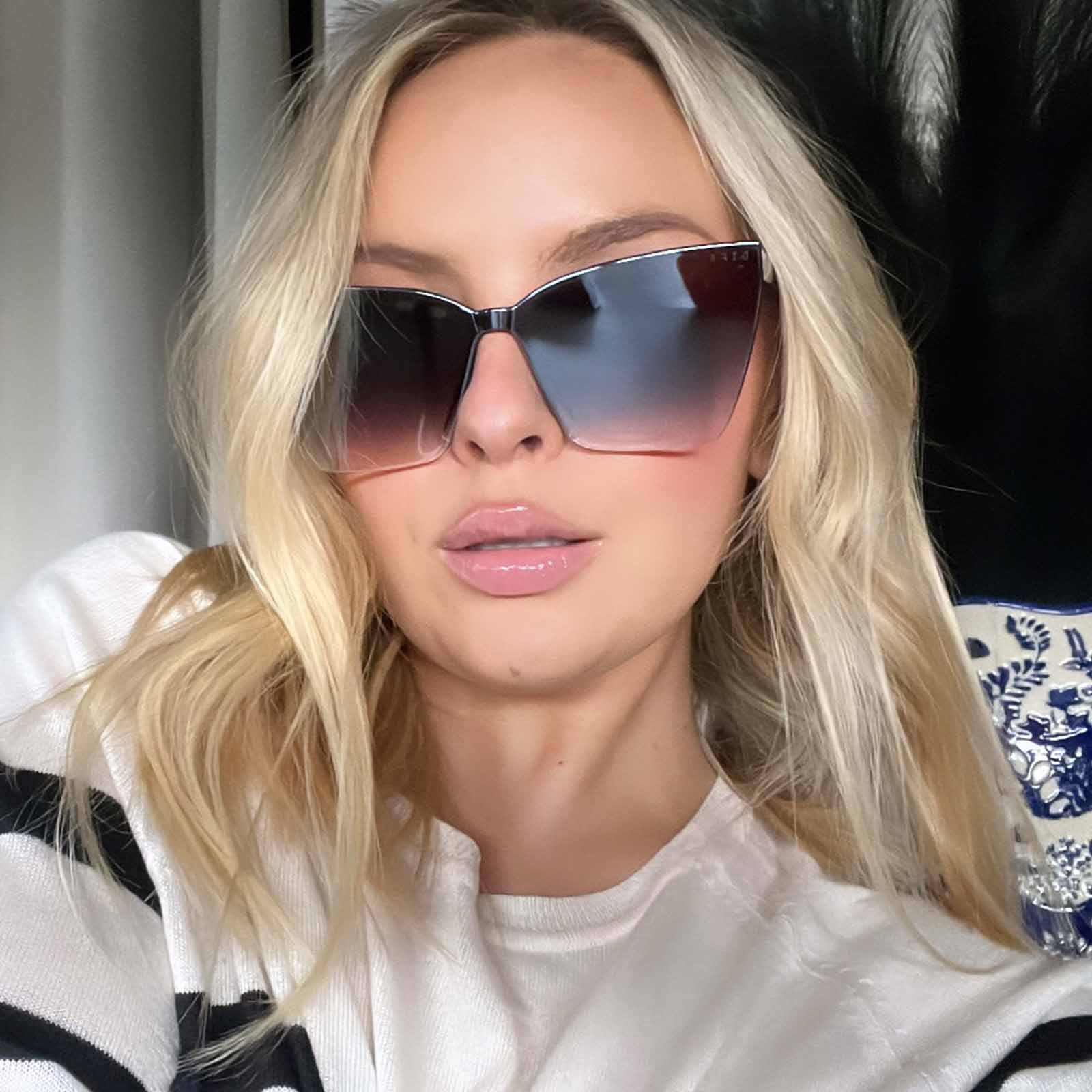 lifestyle - blonde female wearing diff eyewear goldie shield sunglasses with a black frame and smoke to flash lenses