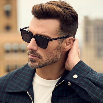 on model - male looking away from the camera while wearing the diff eyewear billie square sunglasses with a black acetate frame and grey polarized lenses