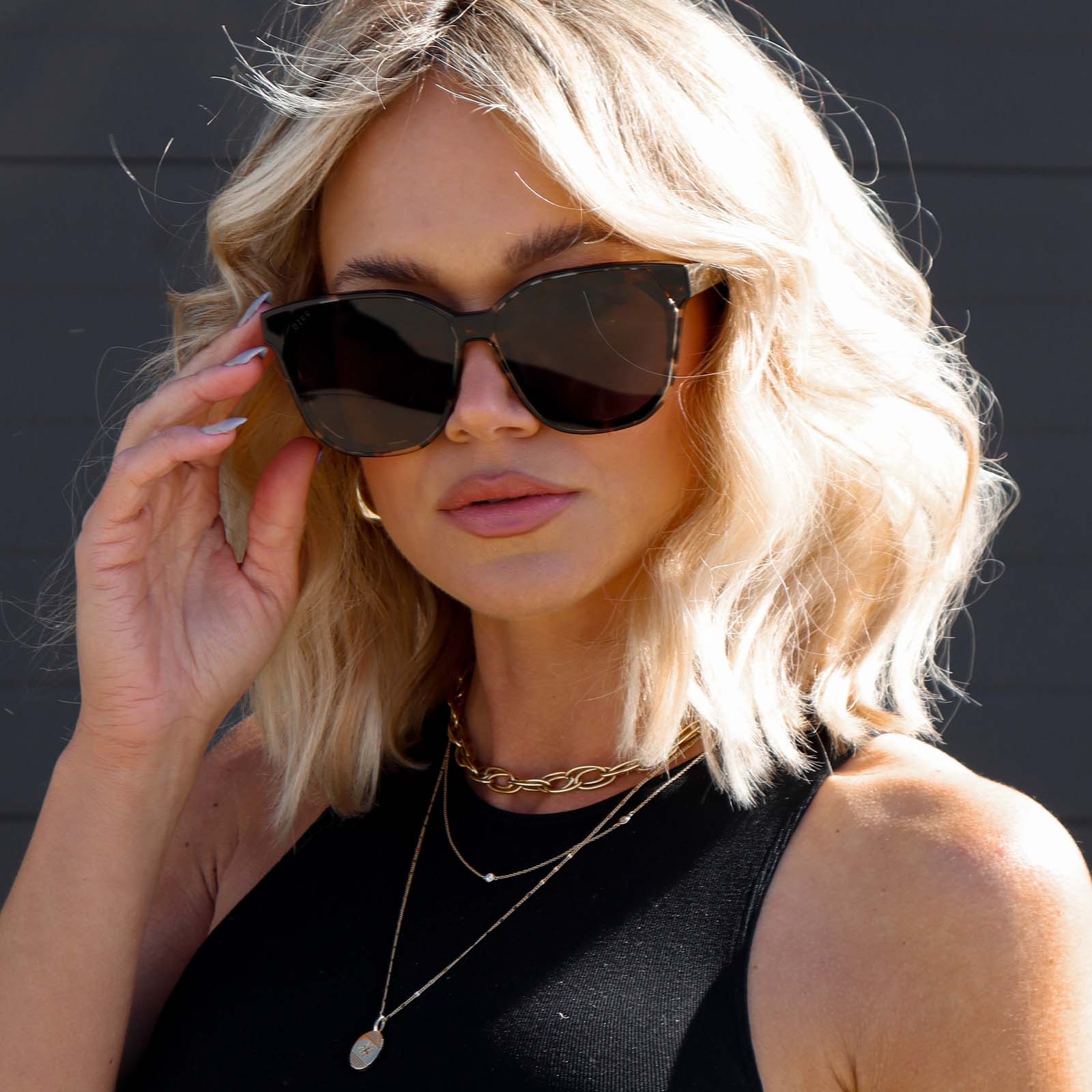 blonde model wearing gia espresso tort sunglasses