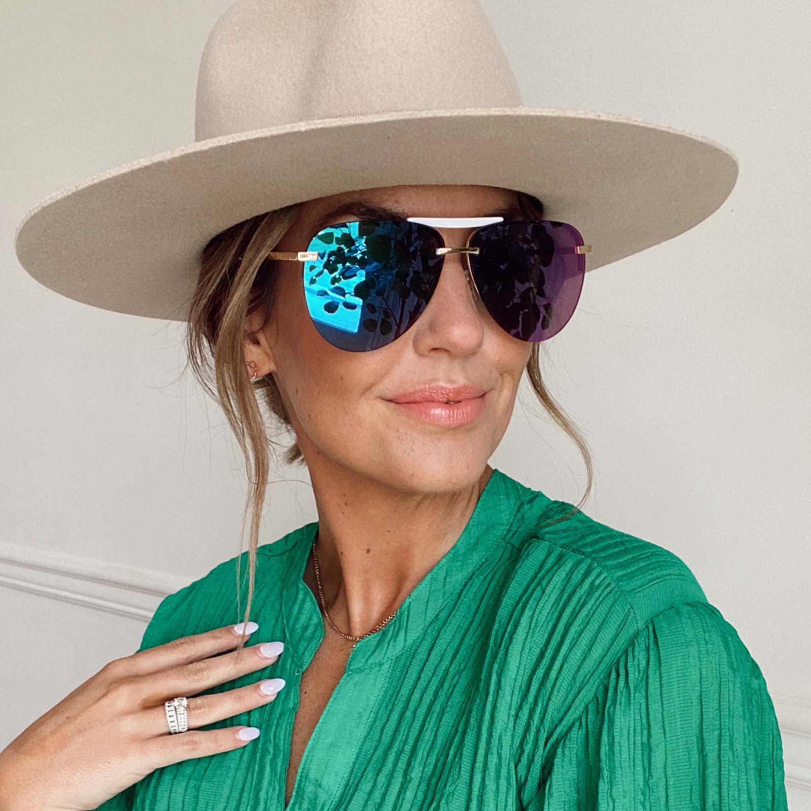 customer content - female wearing a hat and diff eyewear tahoe aviator sunglasses with a gold frame and purple mirror lenses