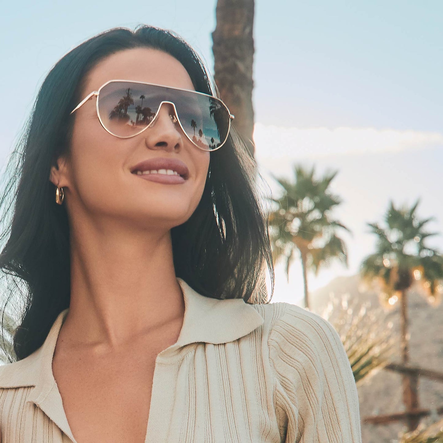 on model - female wearing diff eyewear dash shield oversized sunglasses with a gold metal frame and brown gradient lenses angled view