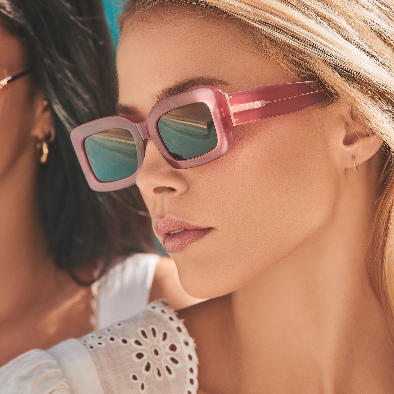 lifestyle- blonde model wearing small indy guava pink sunglasses