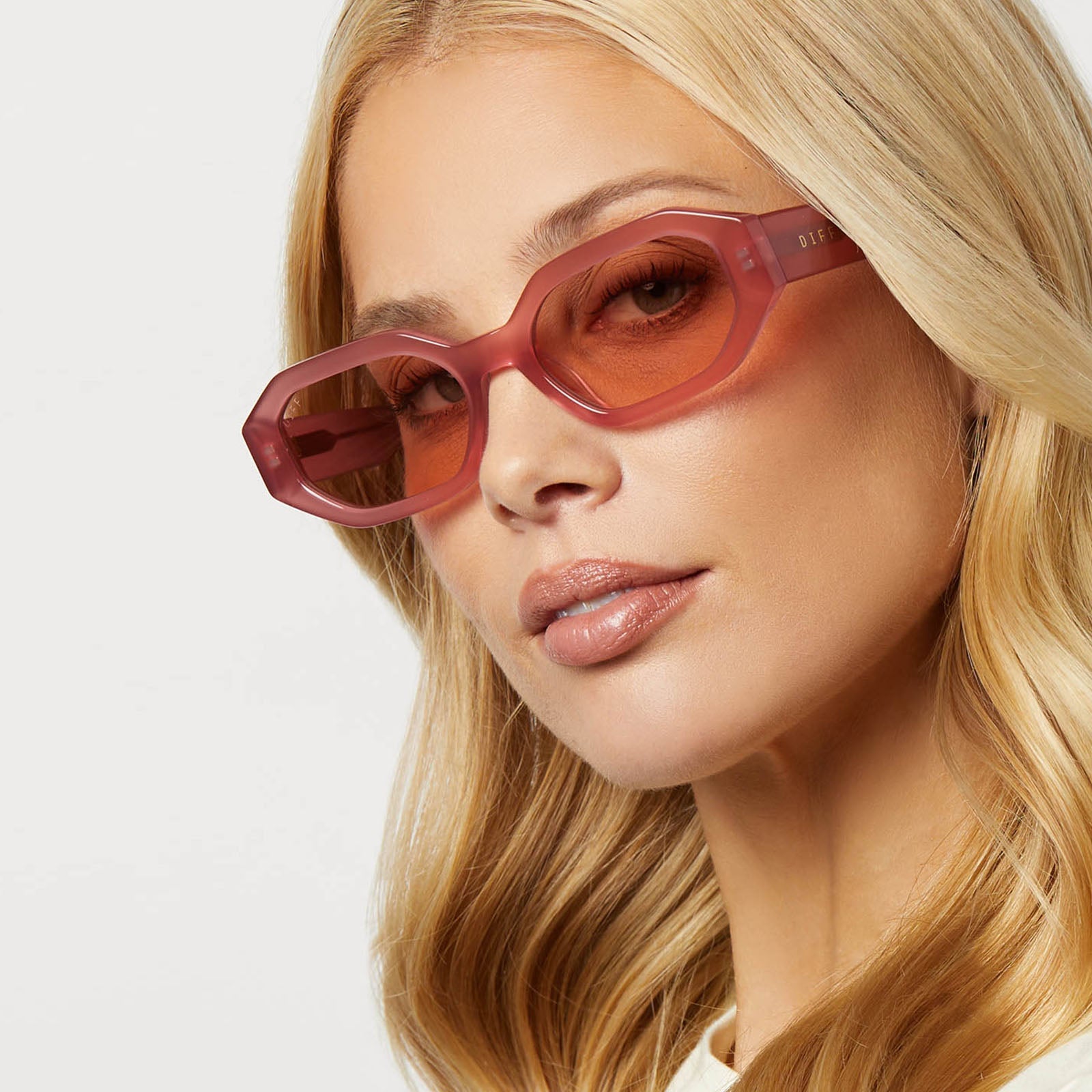 on model - blonde female wearing diff eyewear featuring the allegra rectangle sunglasses with a guava pink frame and guava lenses angled view