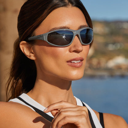 lifestyle - female walking on the beach while wearing diff sport lightning sunglasses in grey