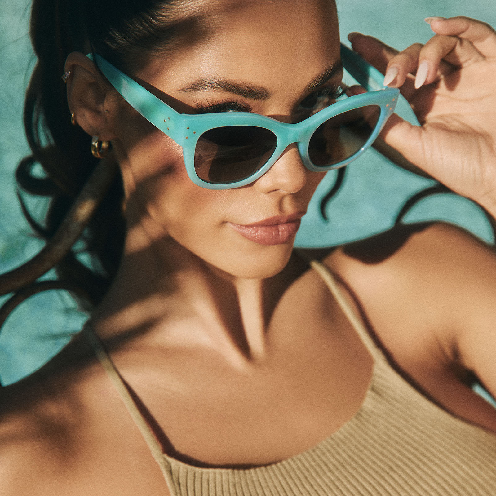 on model - female near a swimming pool wearing iconica x diff eyewear eva cat eye sunglasses with a parasido blue frame and grey gradient polarized lenses angled view