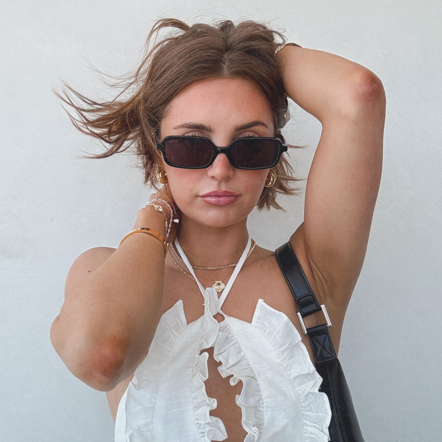 lifestyle - aspyn ovard x diff eyewear female wearing the elle rectangle sunglasses with a black frame and grey lenses front view