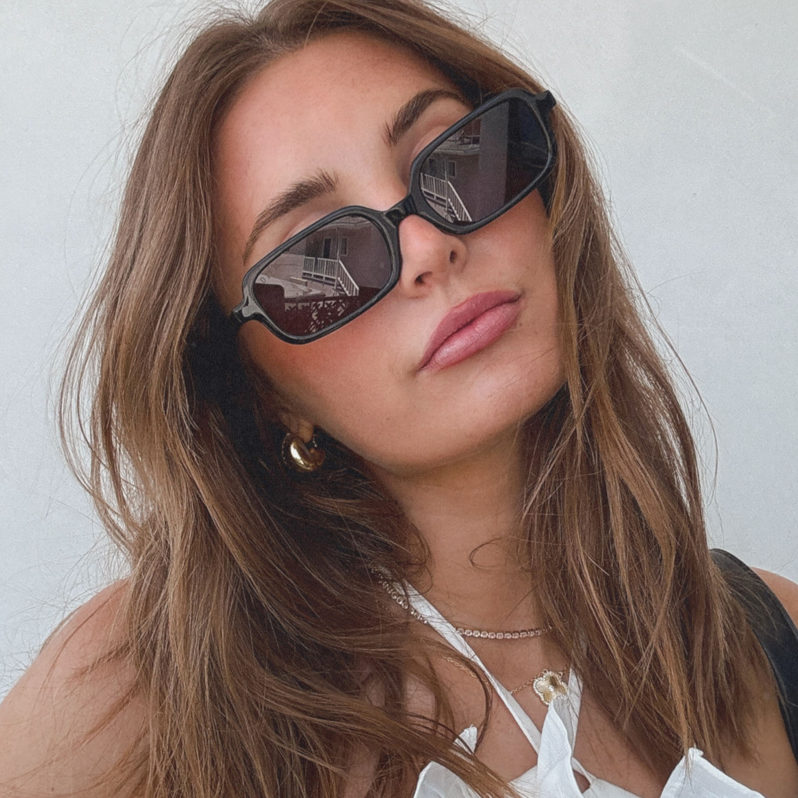 lifestyle - aspyn ovard x diff eyewear female wearing the elle rectangle sunglasses with a black frame and grey lenses front view