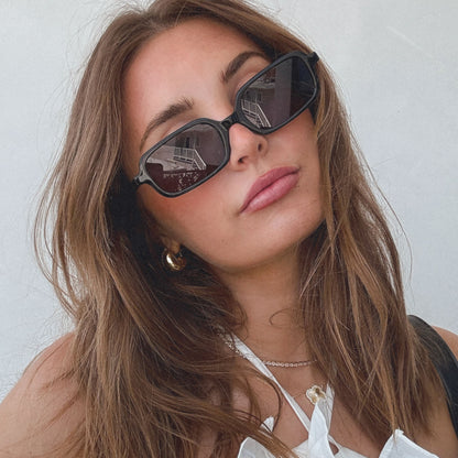 lifestyle - aspyn ovard x diff eyewear female wearing the elle rectangle sunglasses with a black frame and grey lenses front view
