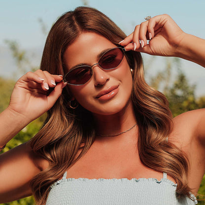 lifestyle - female jojo fletcher putting on diff eyewear jordy cat eye sunglasses with a gold metal frame with horn tortoise temples and brown lenses