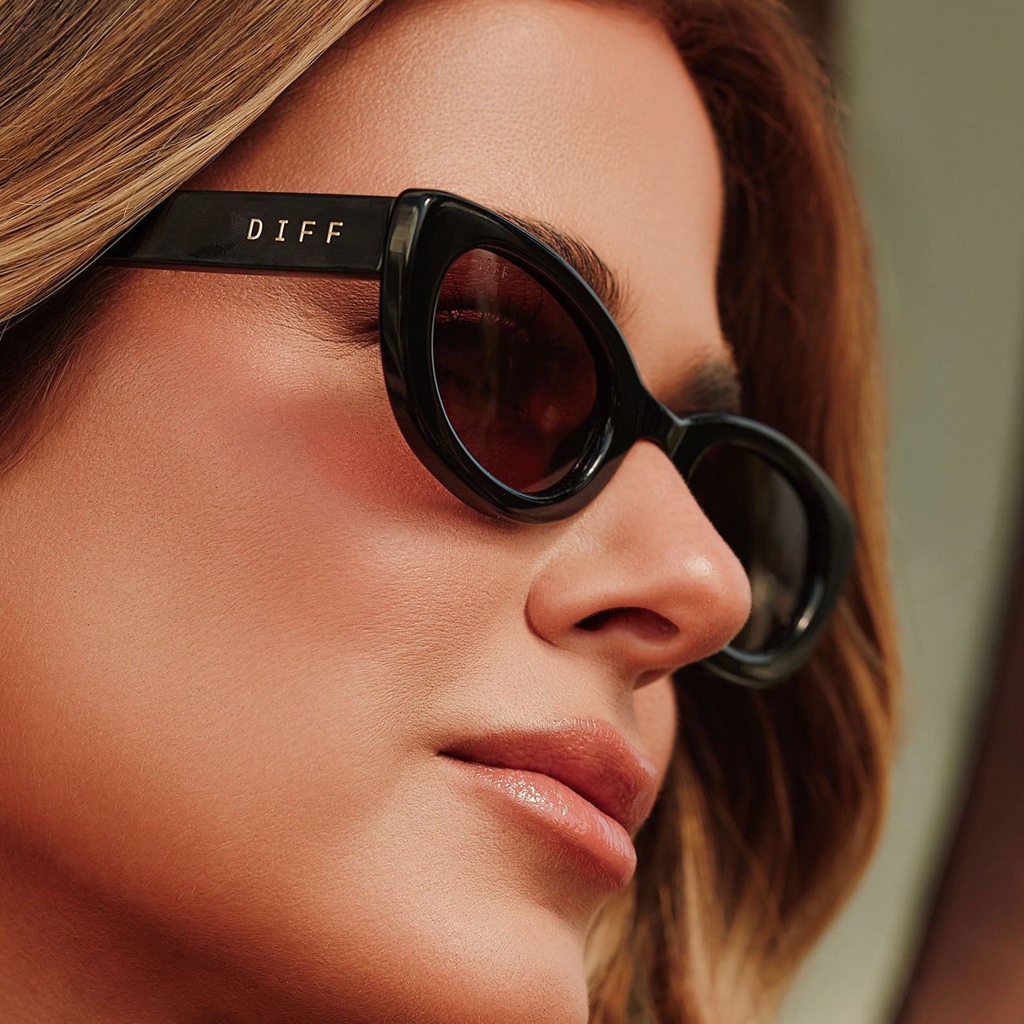 lifestyle - female jojo fletcher wearing diff eyewear jordy round cat eye sunglasses with a black acetate frame and brown lenses detailed view