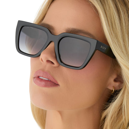 on model - female wearing diff eyewear featuring the amara square sunglasses with a black frame and grey gradient lenses angled view