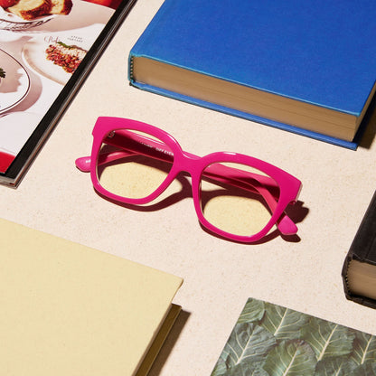 lifestyle - diff eyewear featuring the ava square blue light readers with a peony pink frame on a desk