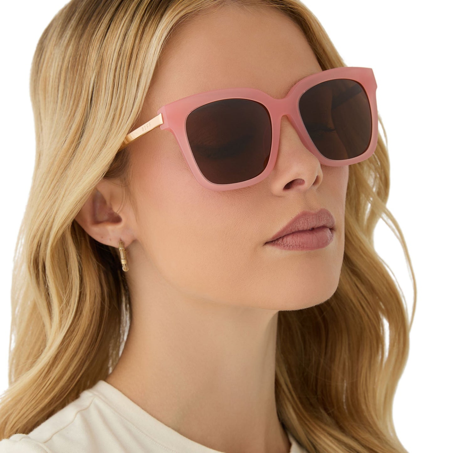on model - female wearing diff eyewear featuring the bella square sunglasses with a peach frame and brown polarized lenses angled view
