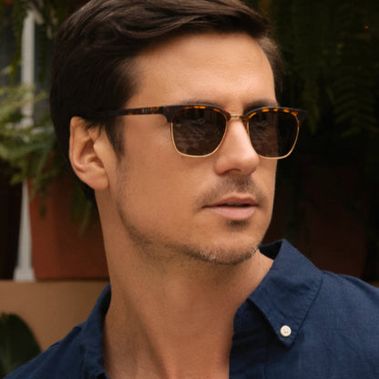 lifestyle - male wearing diff eyewear biarritz square sunglasses with a rich tortoise/gold frame and brown polarized lenses angled view