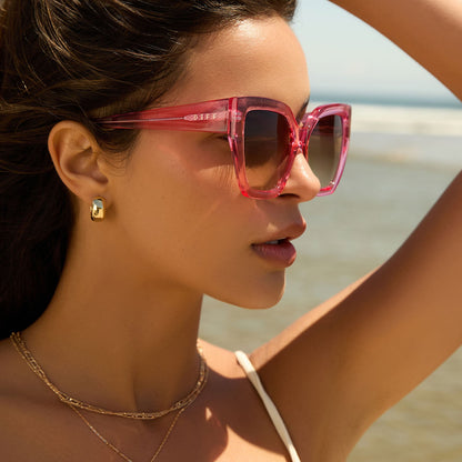 lifestyle - female wearing diff eyewear blaire oversized square sunglasses with a candy pink crystal acetate frame and brown gradient lenses side view