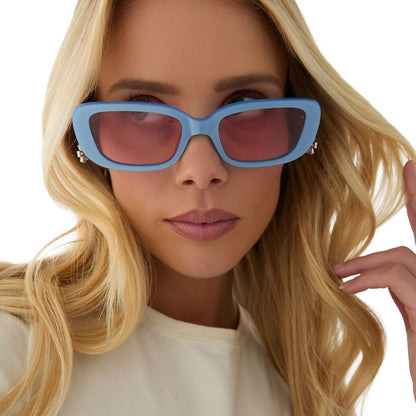on model - female wearing clueless x diff eyewear featuring the cher round sunglasses with a light blue frame and pink gradient lenses front view