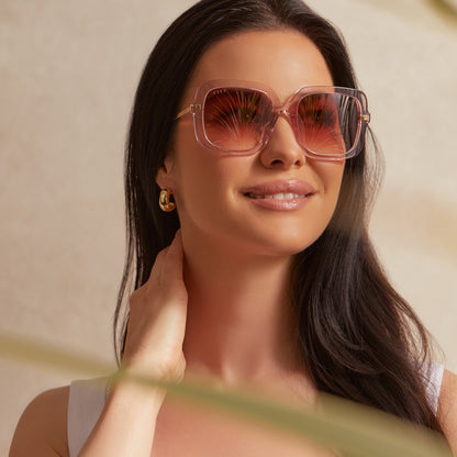 on model - female wearing diff eyewear sandra square sunglasses with a light pink crystal frame and peach dusk gradient lenses front view